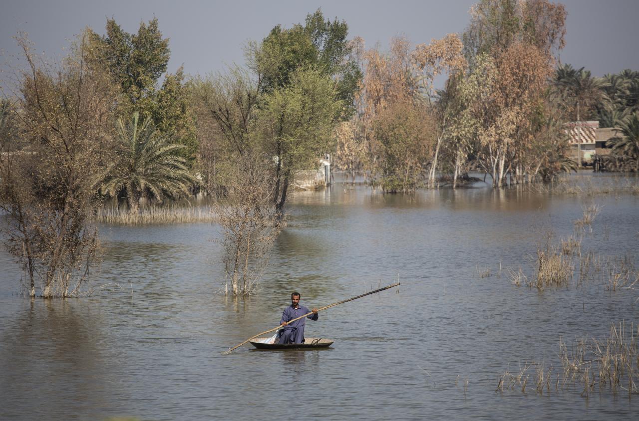 man in small raft floats down a river 