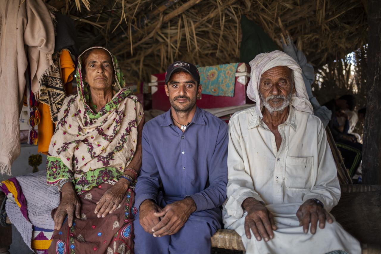 two men and a women sit side by side in a tent looking towards the camera 