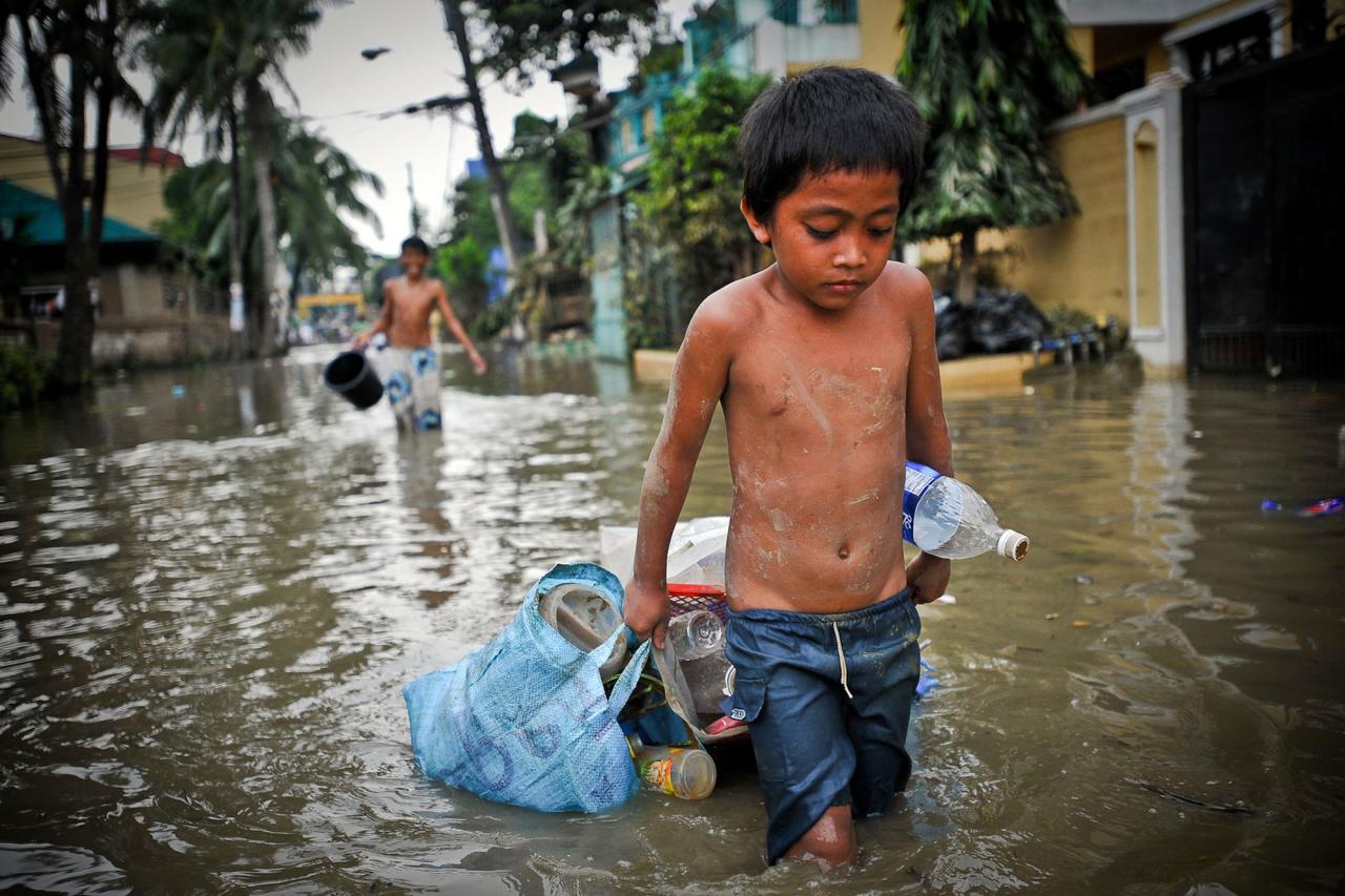 A boy drags possessions through the flooded streets of Manila in the aftermath of a typhoon.