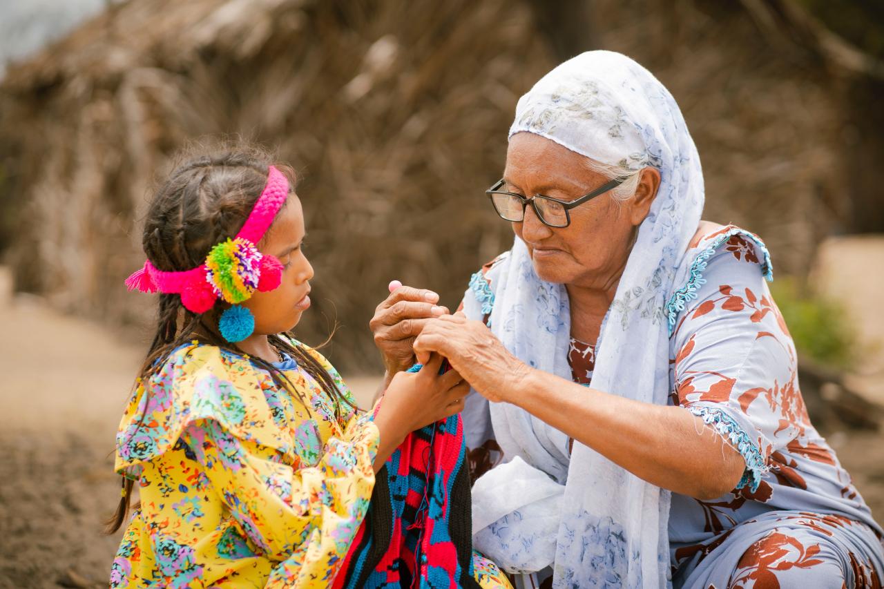 Freyla González (72), senior weawer of Paraguaipoa teaches her granddaughter how to weave in the premises of the yarn cone bank. 