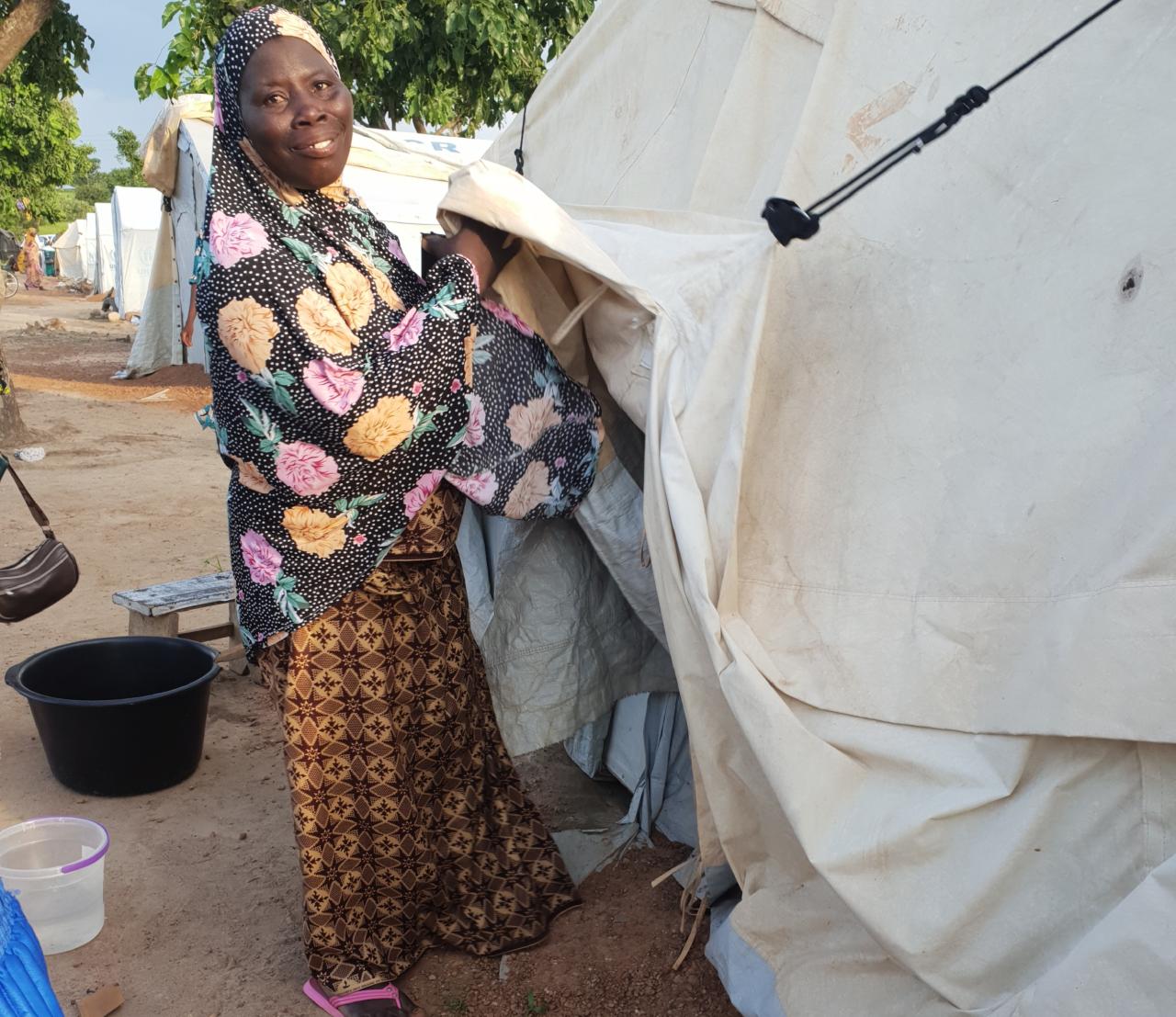 An asylum seeker stands outside her tent at the Tarikom Settlement Centre