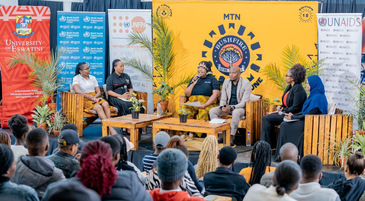 A group of six panelists discuss in front of an audience