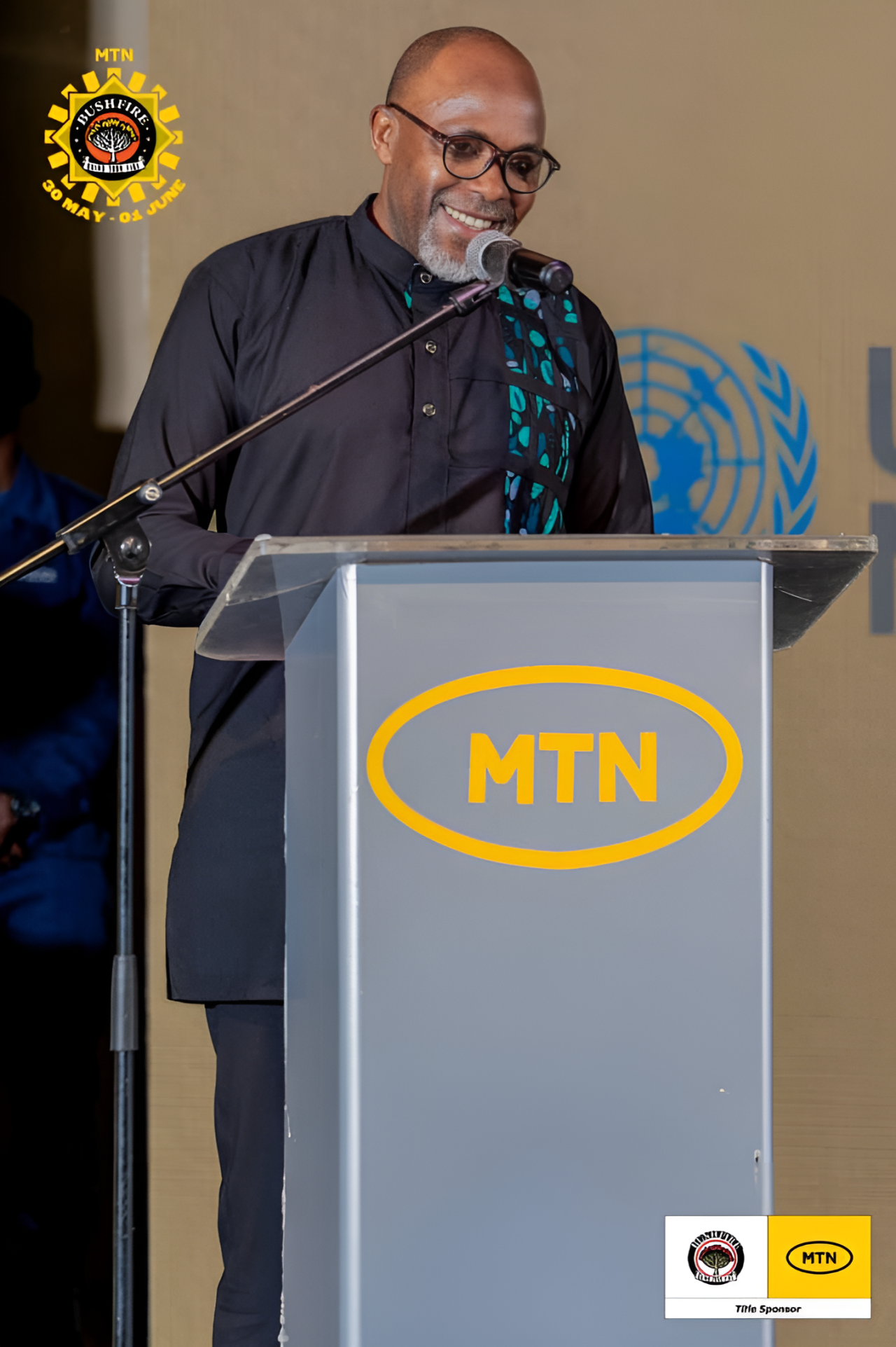 A man speaks into a microphone on a podium
