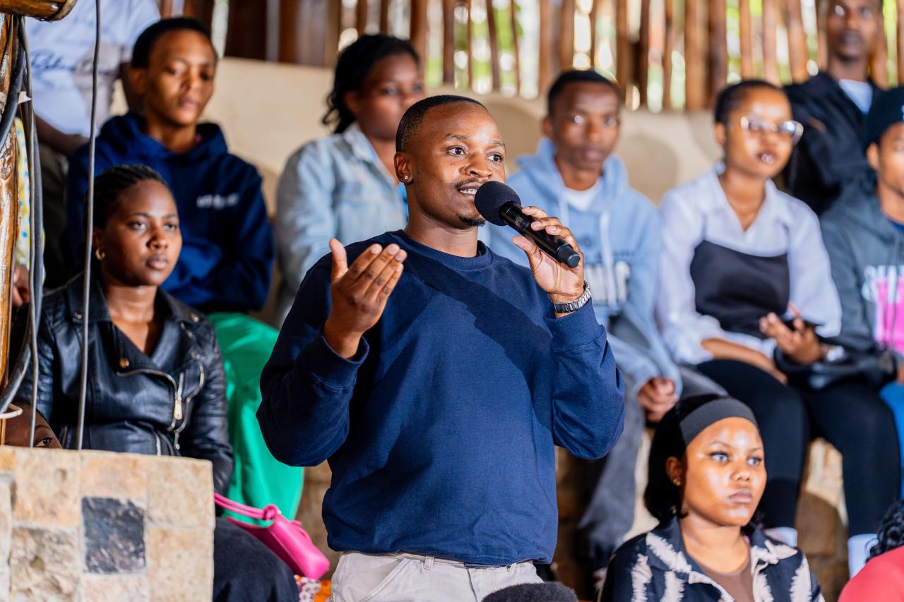 A young man holds a microphone to ask a question