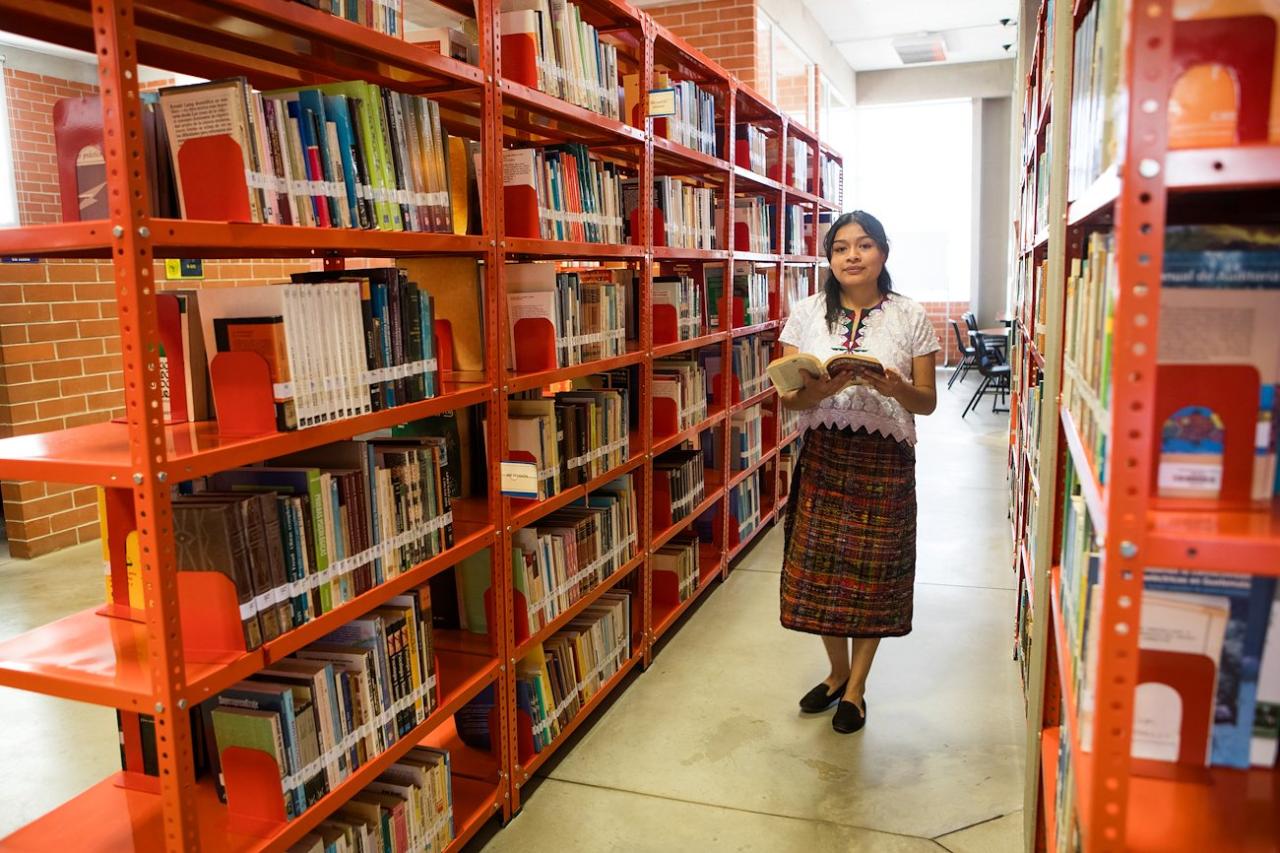 A woman in a library reading a book 