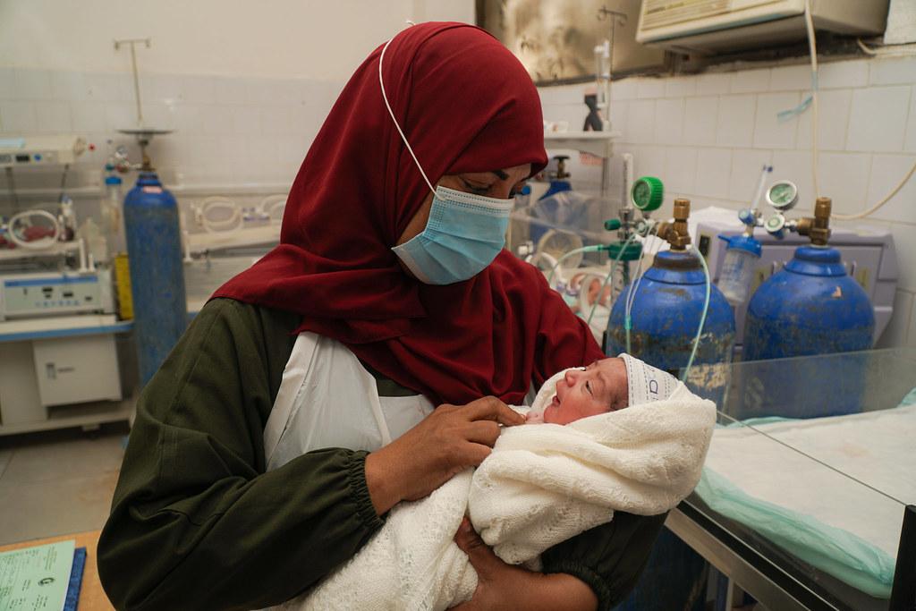 A Yemeni nurse cradles a newborn.