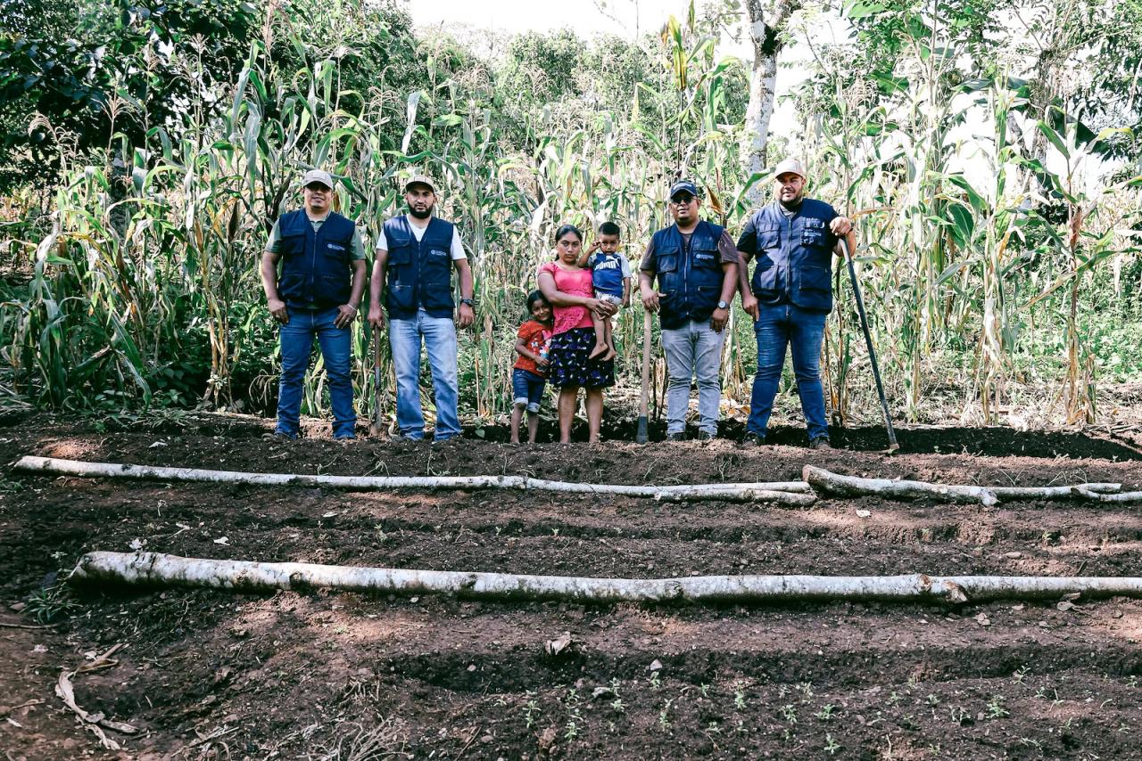 UN staff stand in a field with a local Guatemalan female farmer.