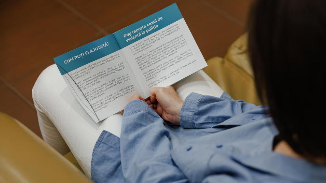 A Moldovan woman reads a pamphlet about gender-based violence.