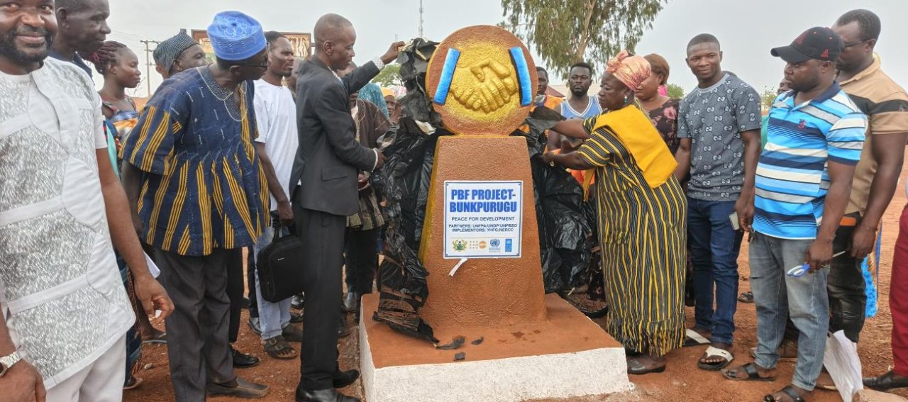 Authorities and community members in northern Ghana unveil a peace plaque.