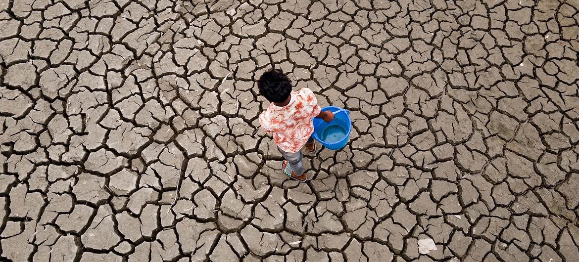 A child walks on land affected by drought.