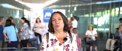 A woman in a flower shirt looks at the camera. 