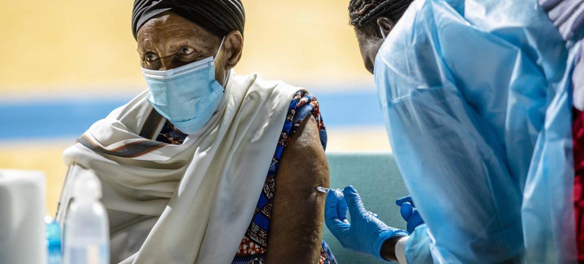 A person in a face mask gets vaccinated. 