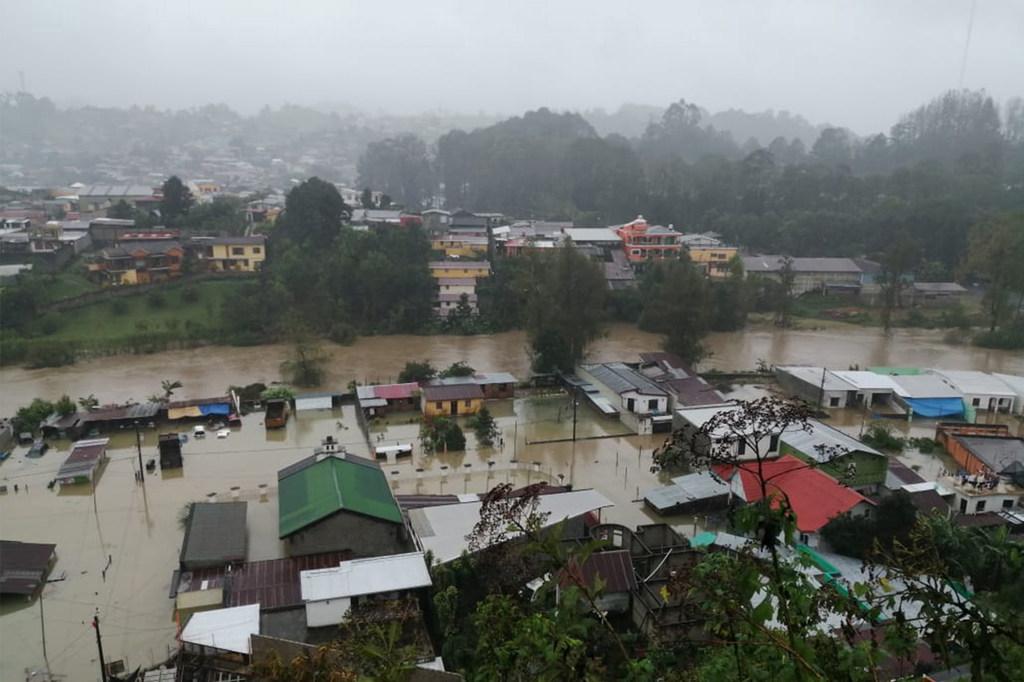 Casas y calles arrasadas por las inundaciones en un día de niebla.