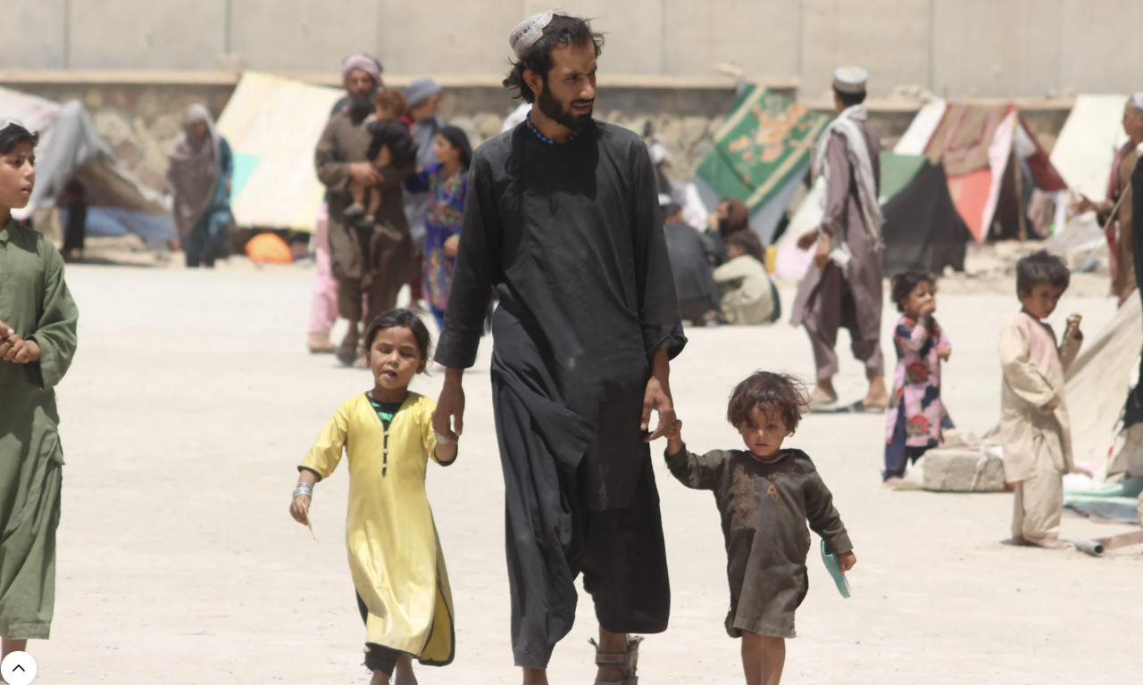 A man walks hand in hand with two boys.