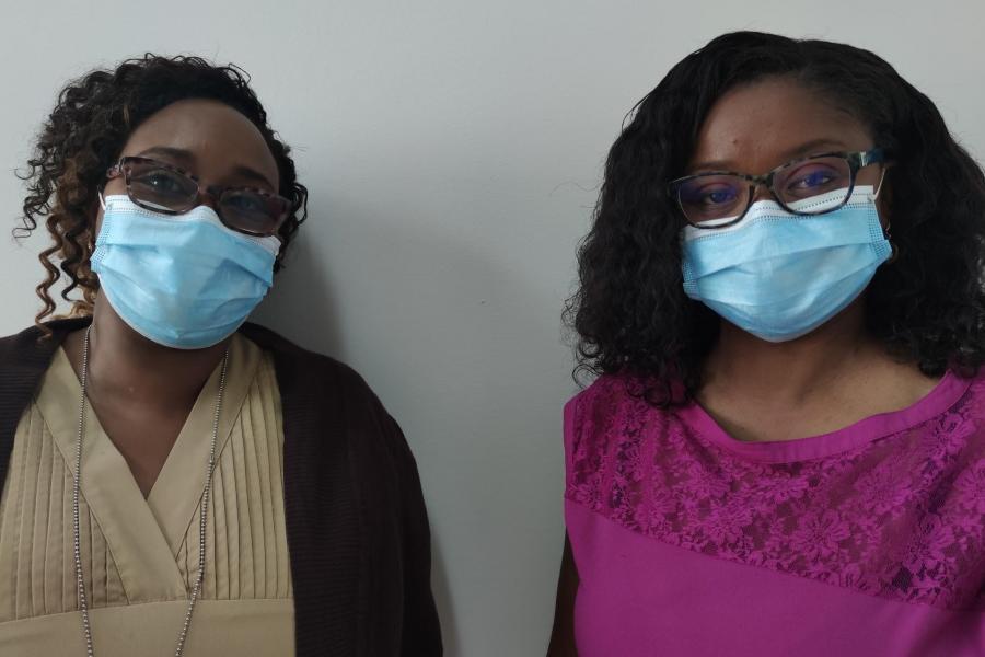 Dos mujeres con mascarillas azules están una al lado de la otra.