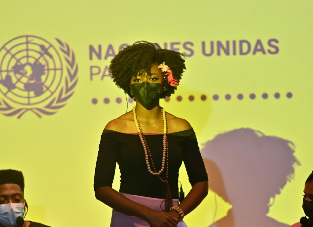 Erika Parker, entrepreneure, philanthrope, personnalité de la télévision et Miss Earth Panama 2017 se tient debout sur une scène, un masque de protection respiratoire sur le nez. 