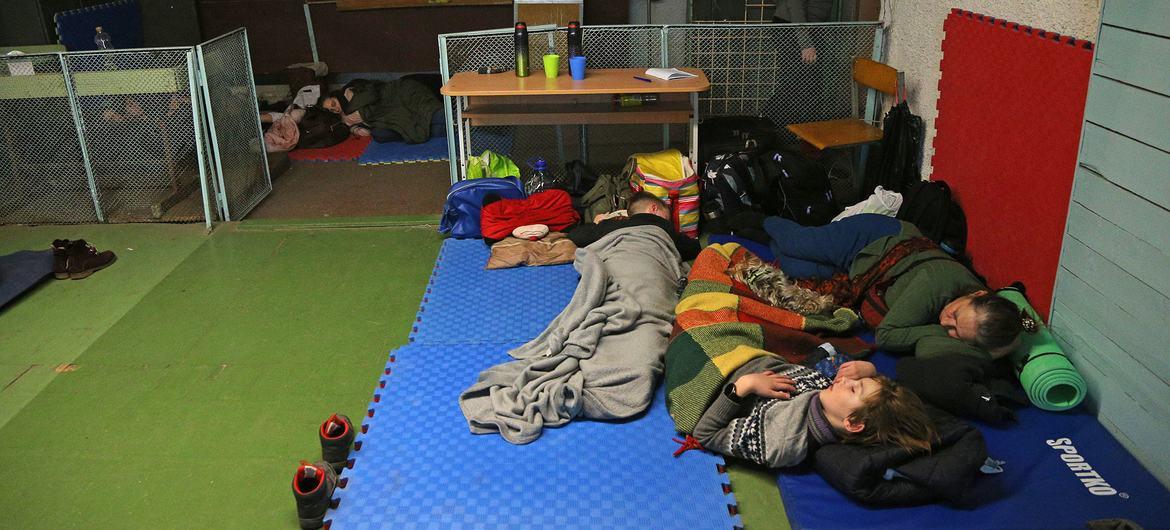Grupo de personas  que se vieron obligadas a refugiarse en una escuela durante las operaciones militares en curso en Kiev, Ucrania.