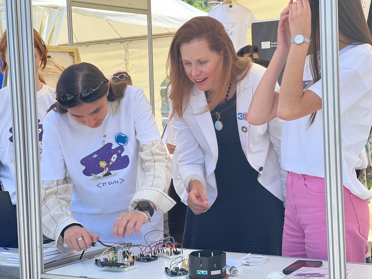 La Coordinadora Residente de las Naciones Unidas en Bosnia y Herzegovina, Ingrid Macdonald, habla con dos niñas que participan en la iniciativa IT Girls en el Festival #ImagineChange en Sarajevo