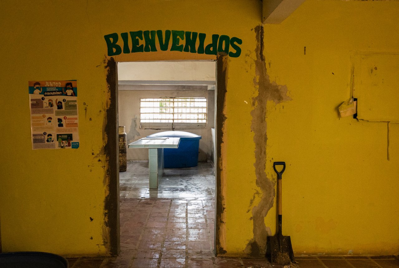 Puerta de entrada de una cocina escolar que está en proceso de su rehabilitación, con cambios en su infraestructura y equipos.
