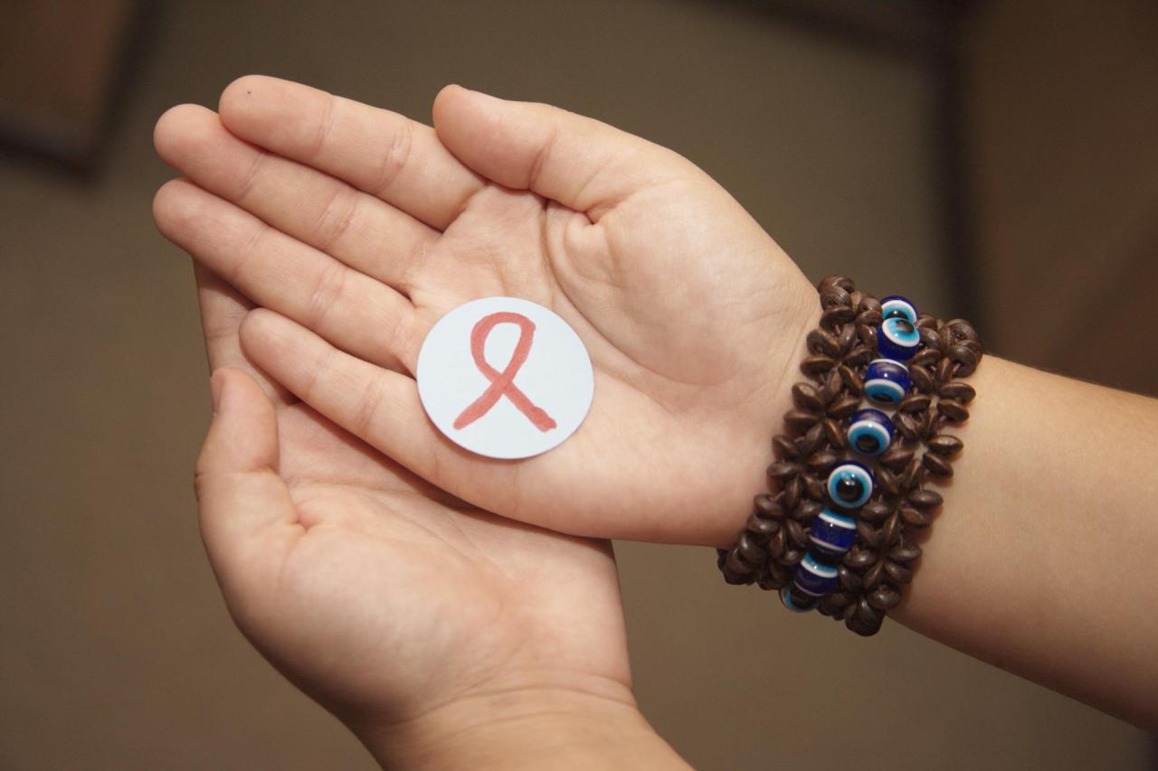 A picture of two palms in each other holding a little circle with a HIV symbol in it