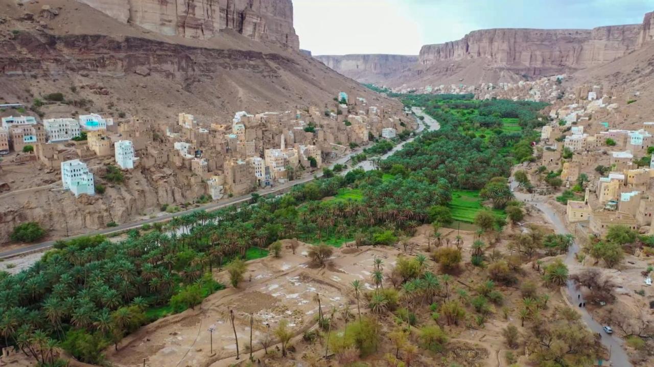 A patch of green grass cutting through a stony ridge-like valley