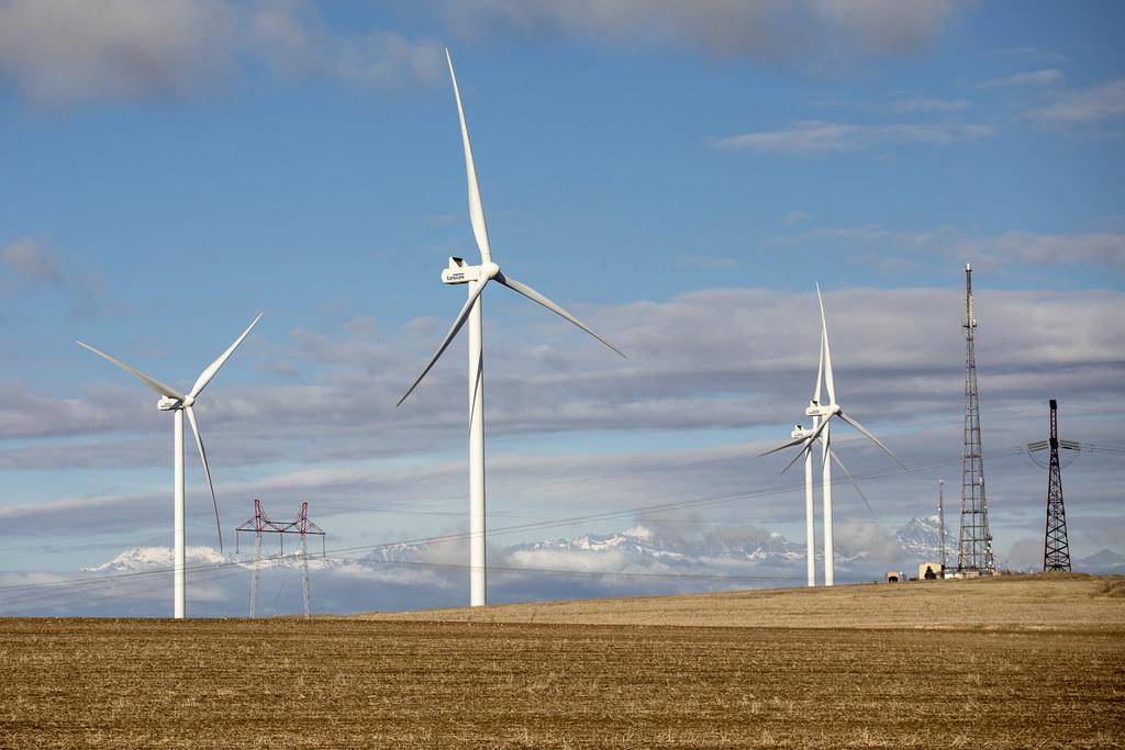 A line of white wind turbines on land in Georgia