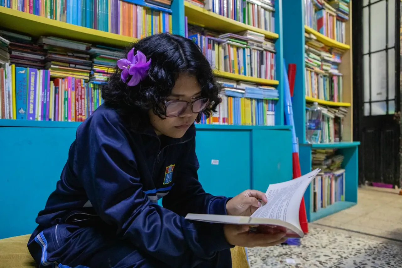 Niña lee en la biblioteca