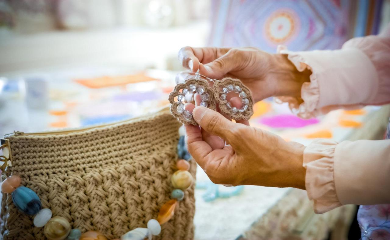 A pair of woman's hands display a crochet project.