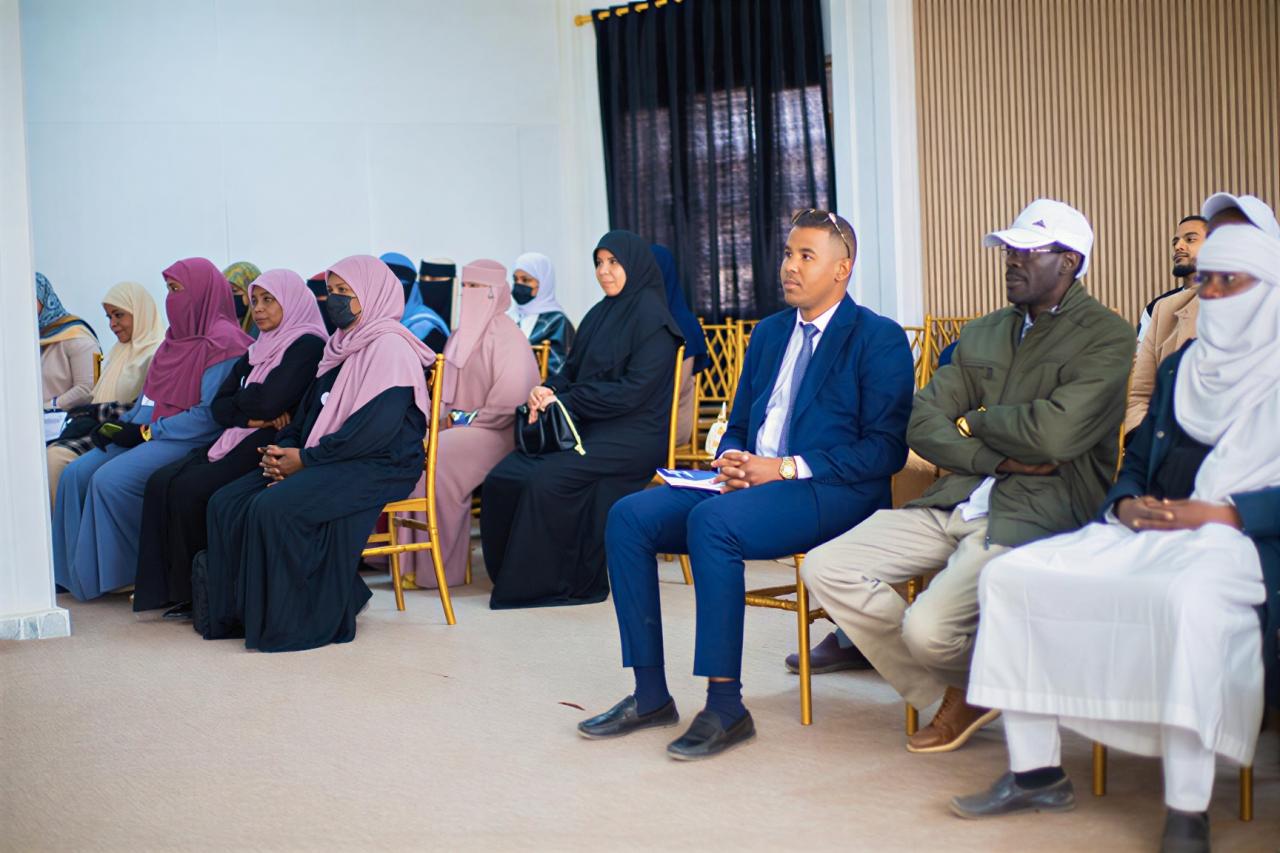 Men and women in Libya listen attentively to a workshop.