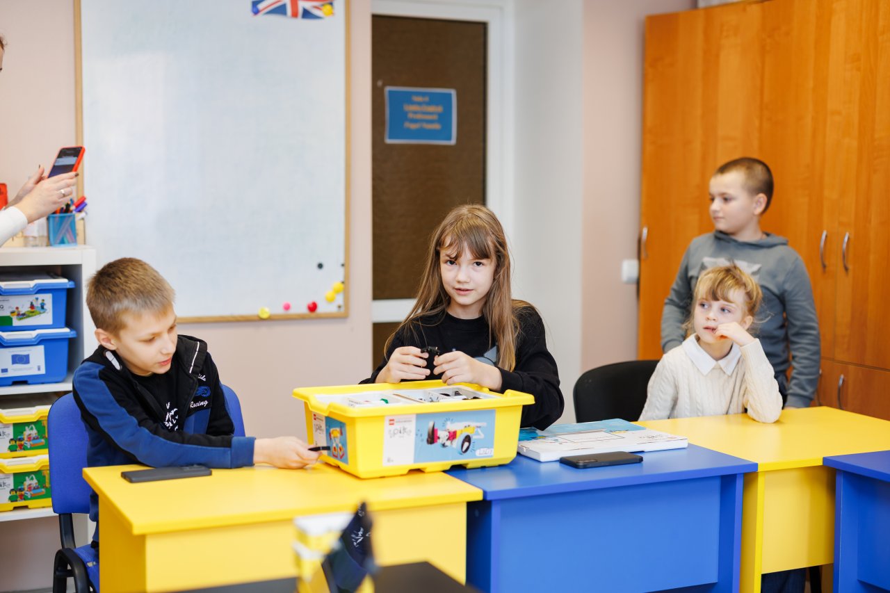 Boys and girls playing with robotics in a classroom in Moldova.