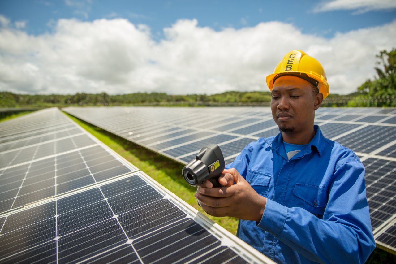 Un hombre en Mauricio trabaja en un panel solar.