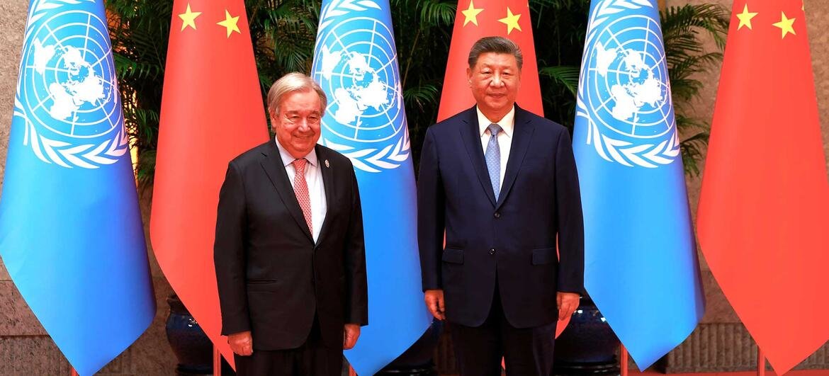 El Secretario General de la ONU y el Presidente de China posan con banderas.