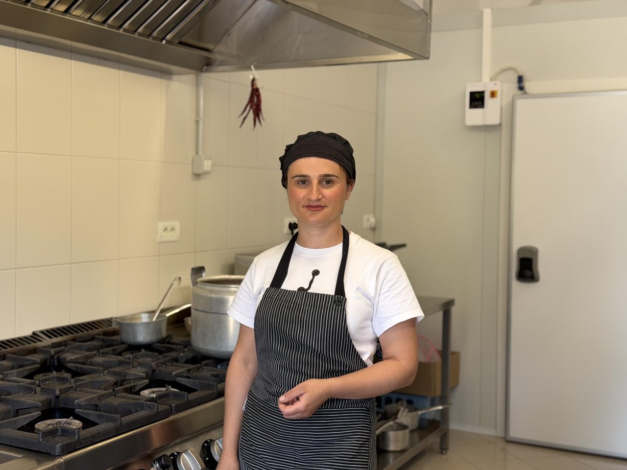 A young cook in Albania stands in a kitchen.