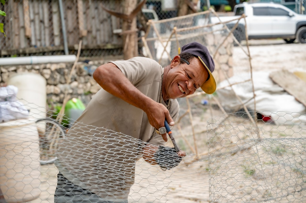 A man in Jamaica cuts a net.