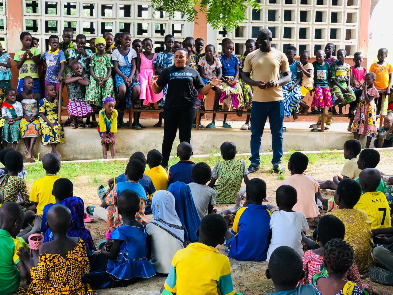Des volontaires du ONU devant un groupe d'enfants.