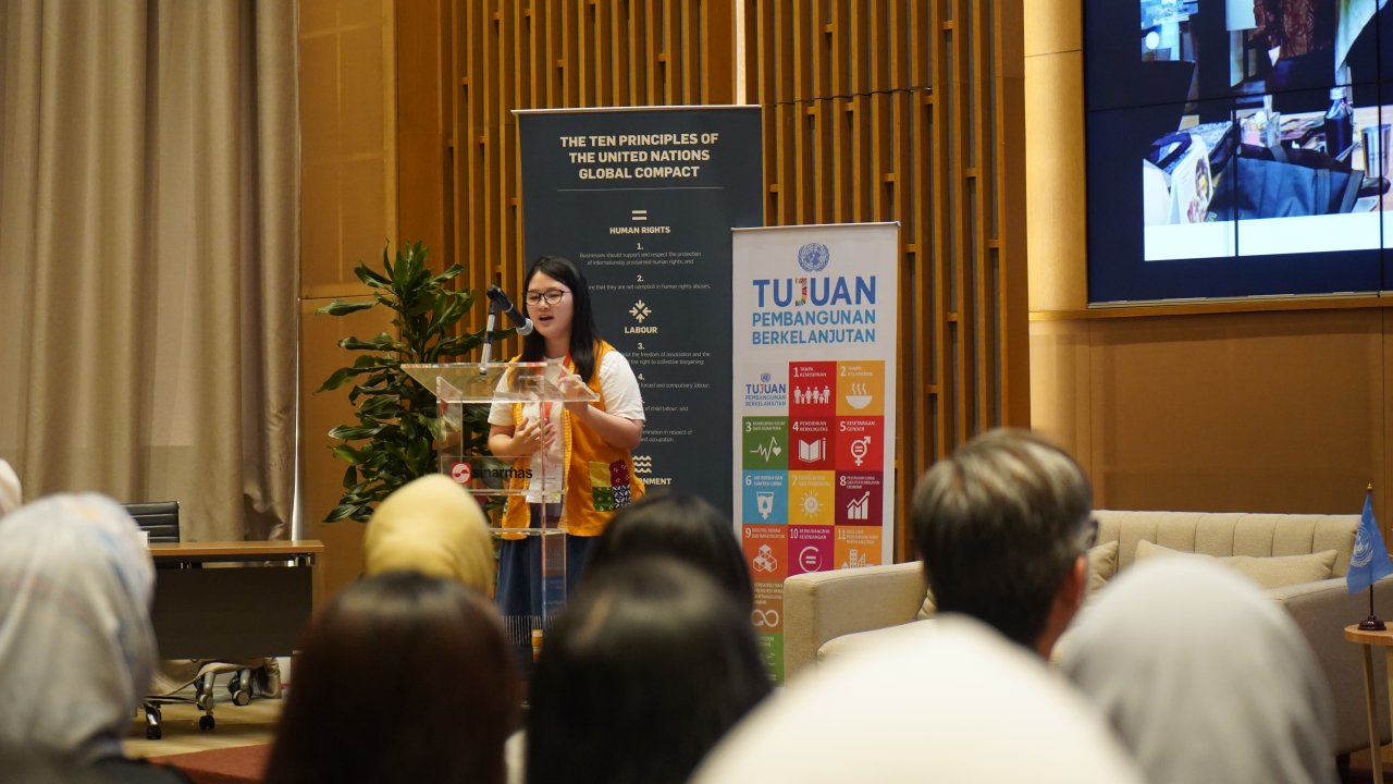 A young woman leader gives a speech during an event in Indonesia.