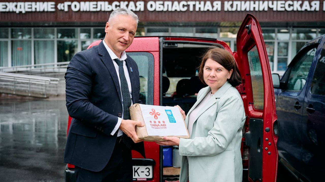 Представитель ООН передает коробку с брошюрами