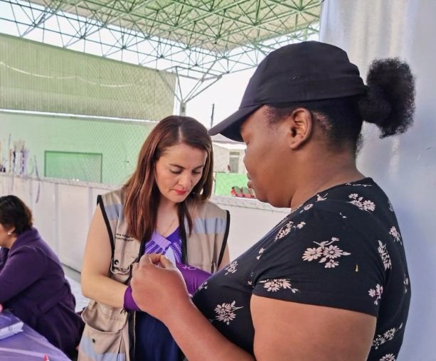Mujer entrega cosas a otra mujer