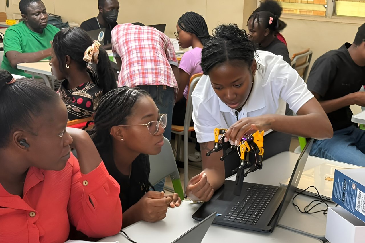 Three girls analyse a robot.