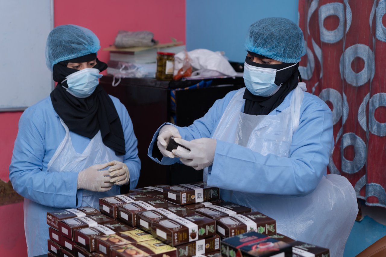 Two farmers in Yemen work in a processing facility.
