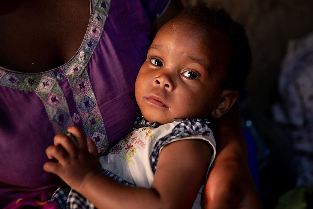 A girl in Uganda in her mother's arms.