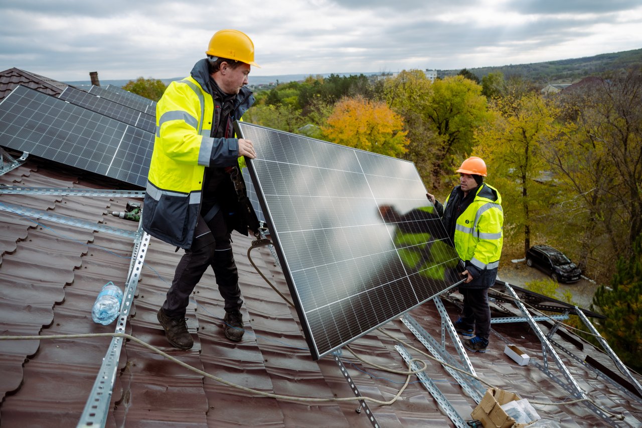 Solar panels being installed on a roof in Moldova.