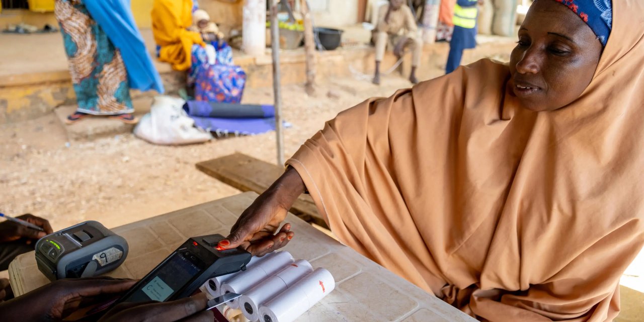 A woman accesses food assistance through the World Food Programme’s e-voucher project, supported by the OCHA-managed Nigeria Humanitarian Fund at a displacement camp in Ngala, Borno State.