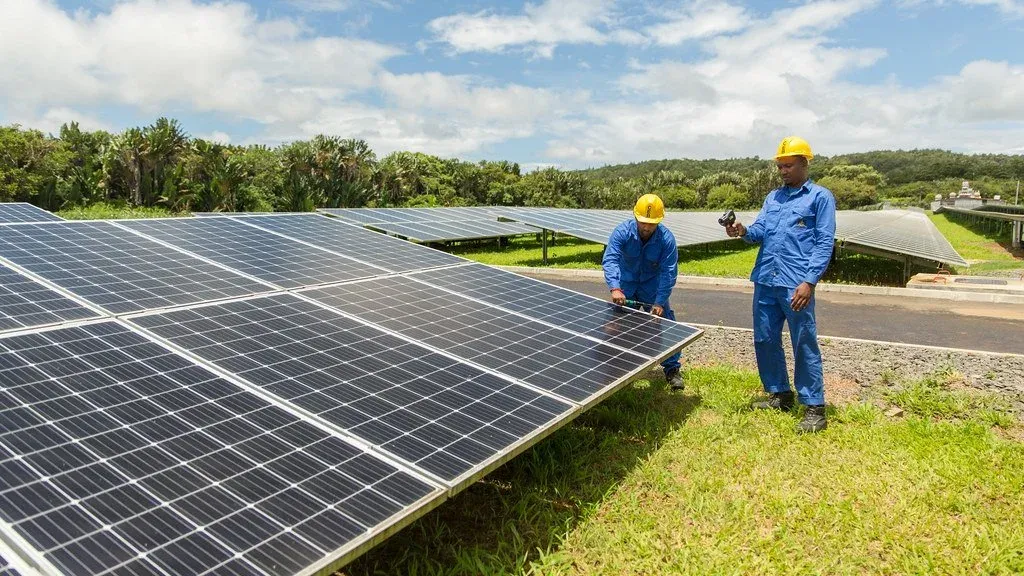 Two workers inspect solar panels