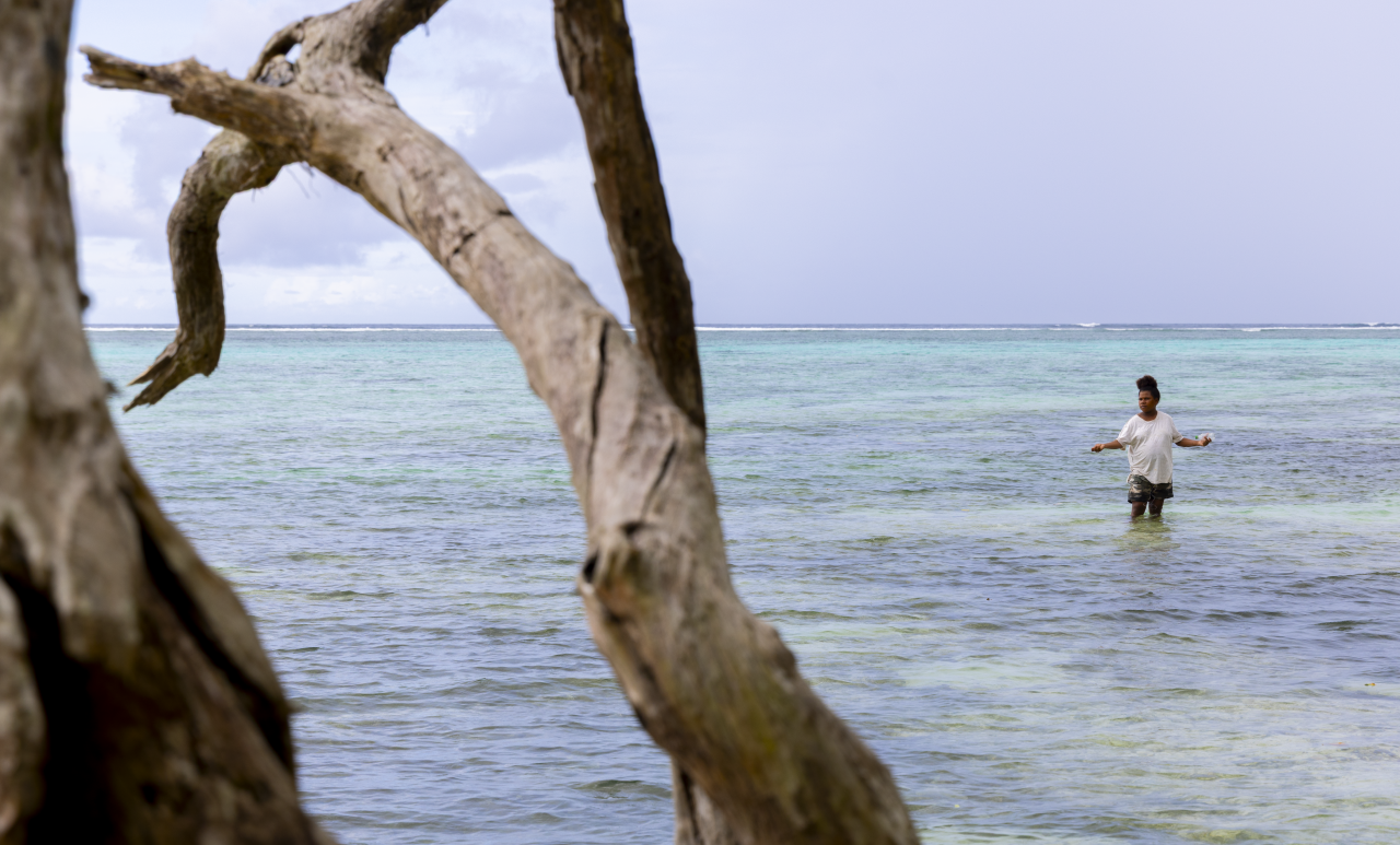 A woman stands in the ocean in Papua New Guinea.