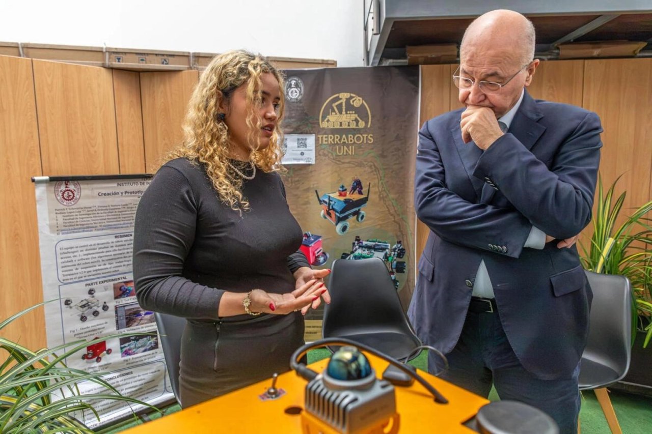 Una joven venezolana le muestra al Alto Comisionado de la ONU para los Refugiados un robot que ella misma construyó.