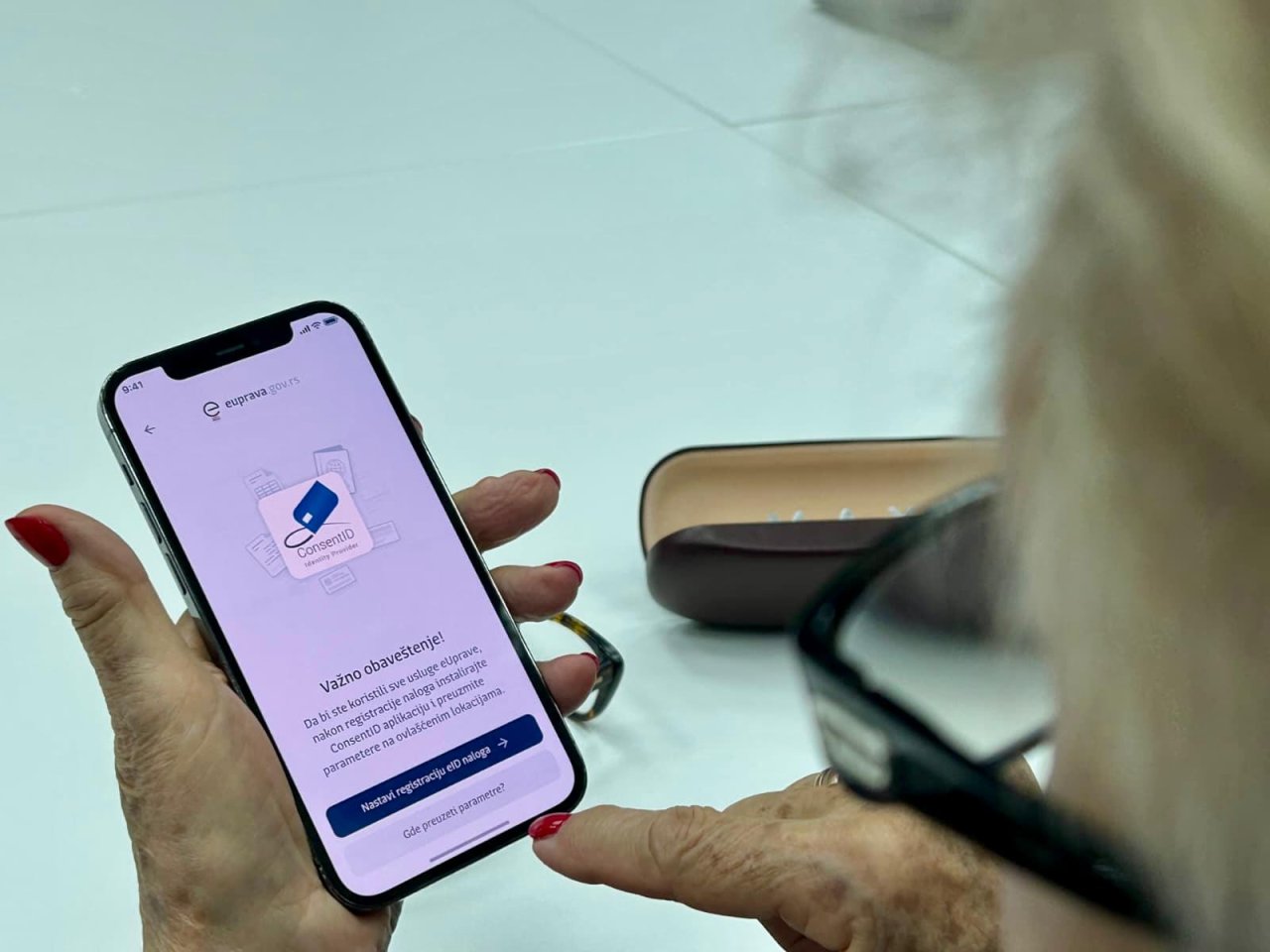 An older person in Serbia uses a cell phone.