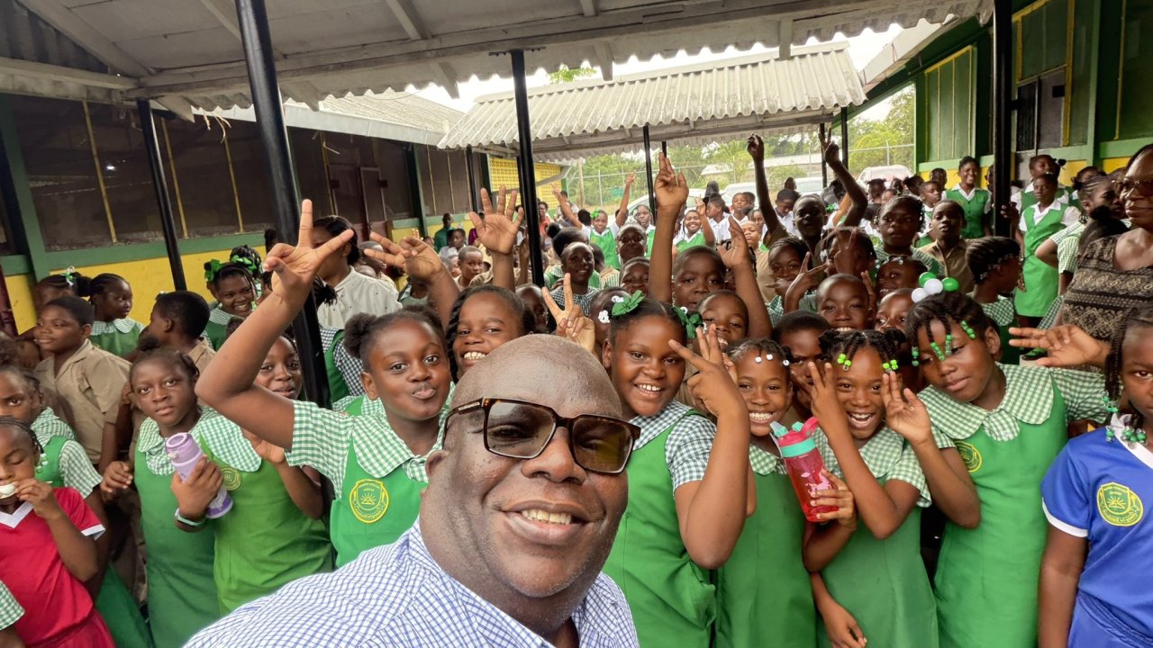 The UN Resident Coordinator in Jamaica takes a photo with students.