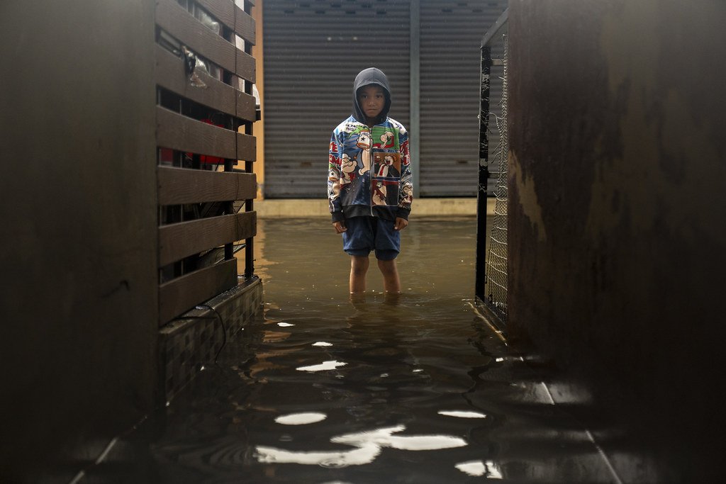 A child in Thailand stands in floodwater.