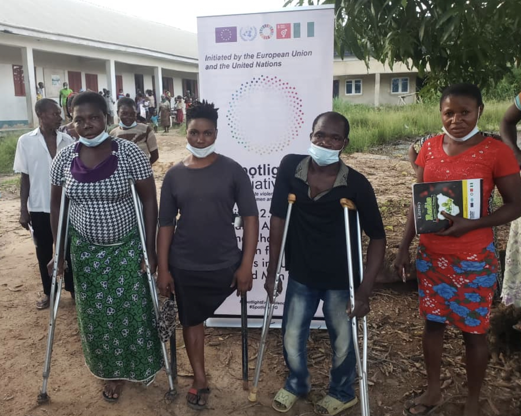 أربعة طلاب يقفون خارج مبنى بالقرب من لافتة بيضاء لمبادرة Spotlight.